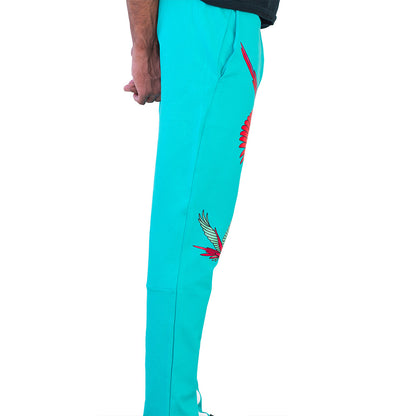 Turquoise Mariano track pants with red and blue bird prints and white side panels in a slim athletic fit.